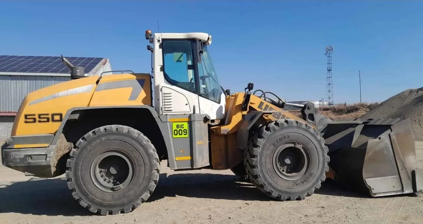 A yellow and white Liebherr L550 wheel loader, fleet number BIC 009.