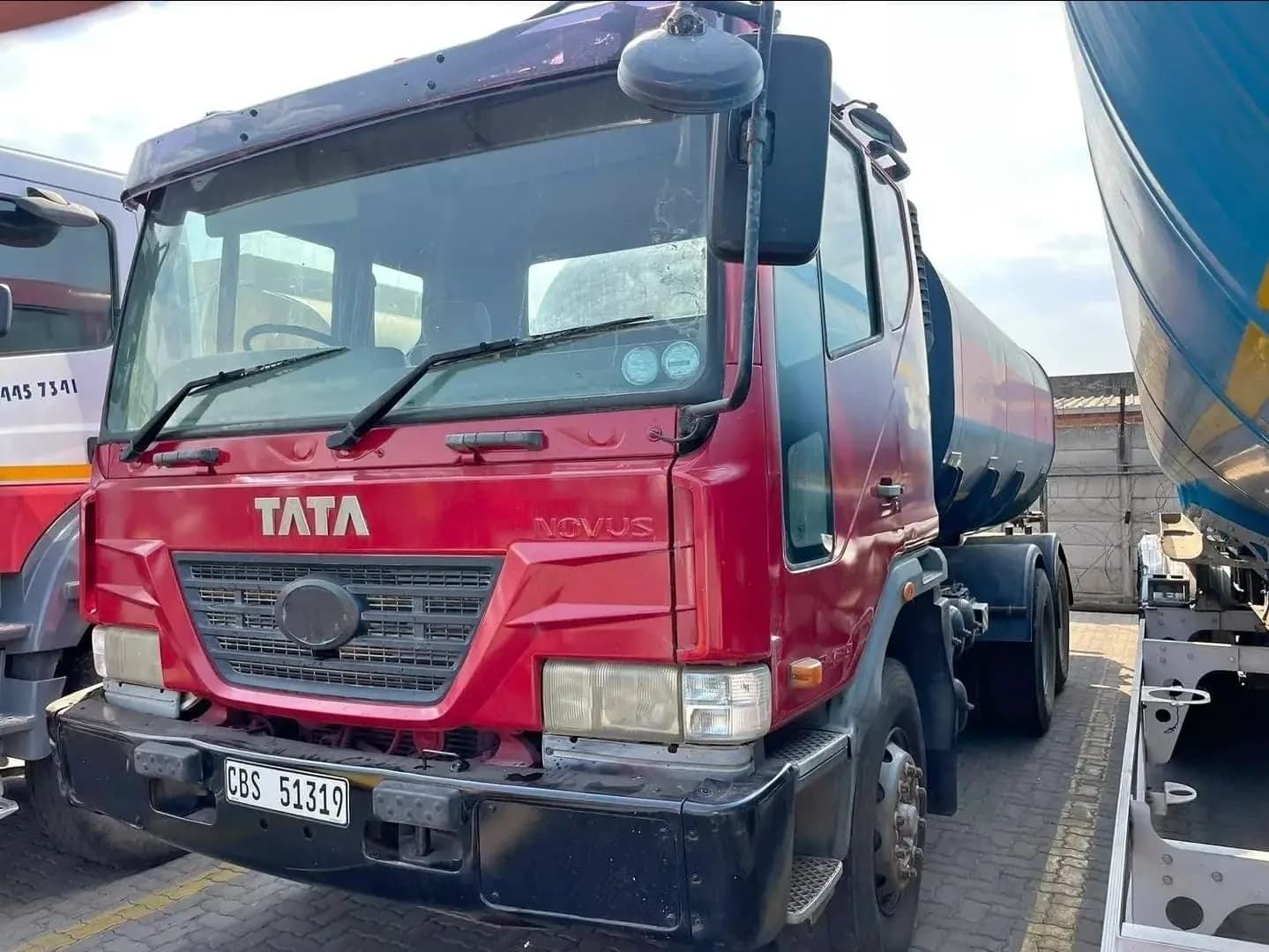 A red TATA Novus water tanker truck.