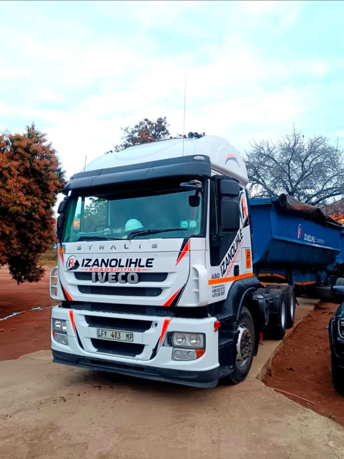 An Iveco Stralis truck-tractor in full Izanolihle Roads livery, coupled to a side-tipper trailer.